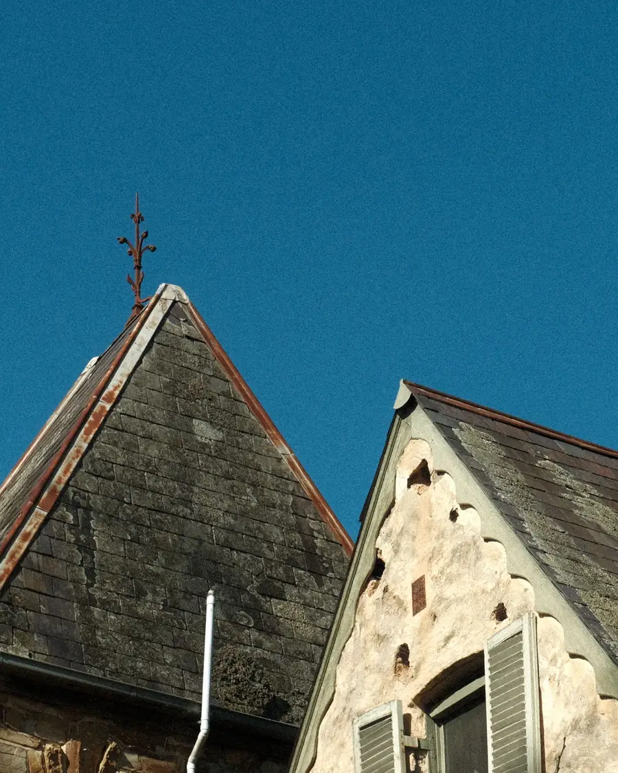 Steep natural slate roof with pale patches of lichen across the slates