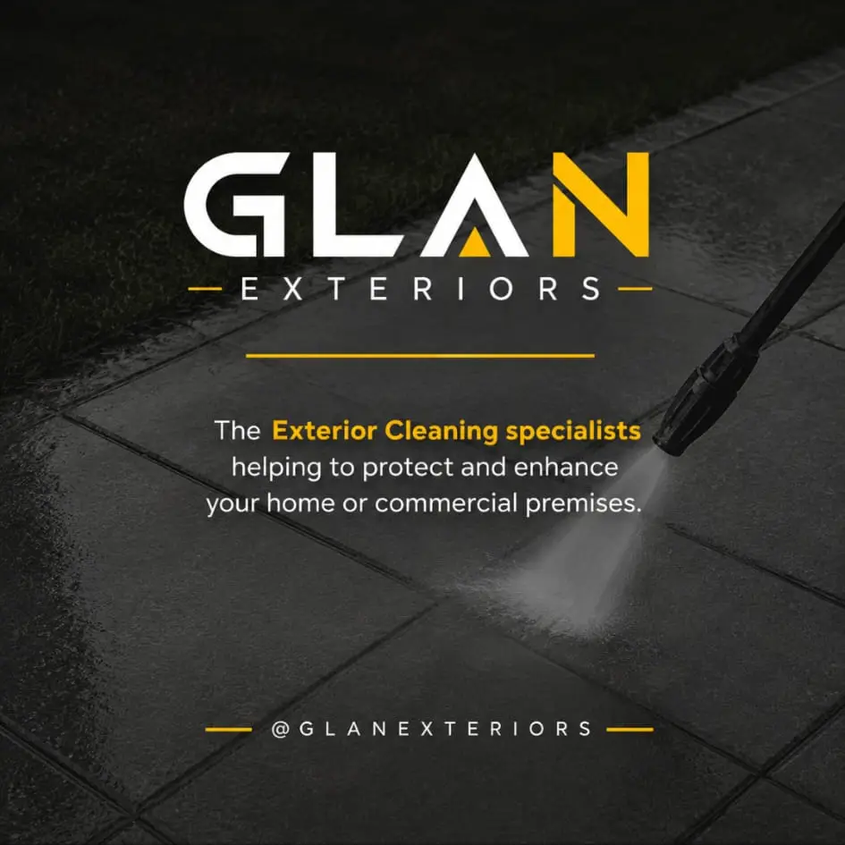 A paved surface being jet washed, the cleaned strip clearly lighter than the rest