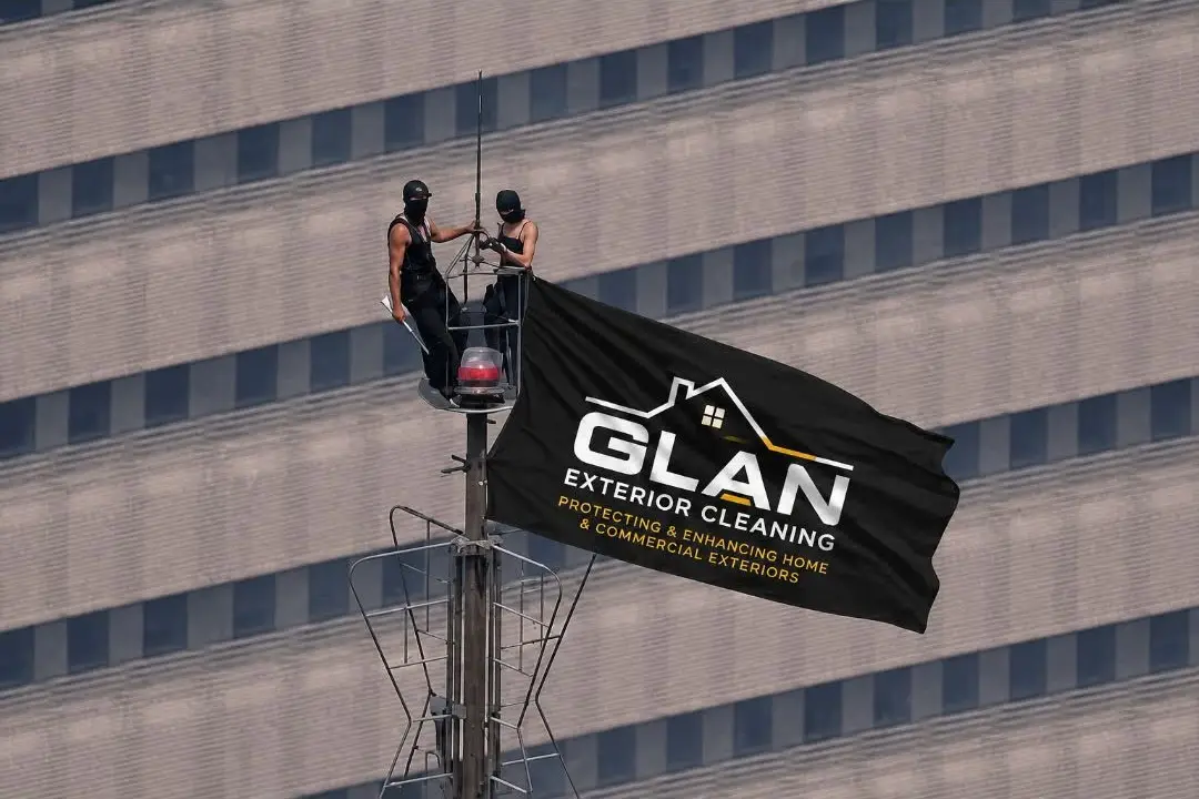 Two operatives working from a mast platform on a multi-storey commercial elevation