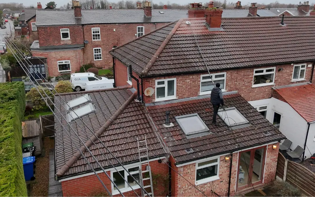 An interlocking tile roof with patchy moss and lichen